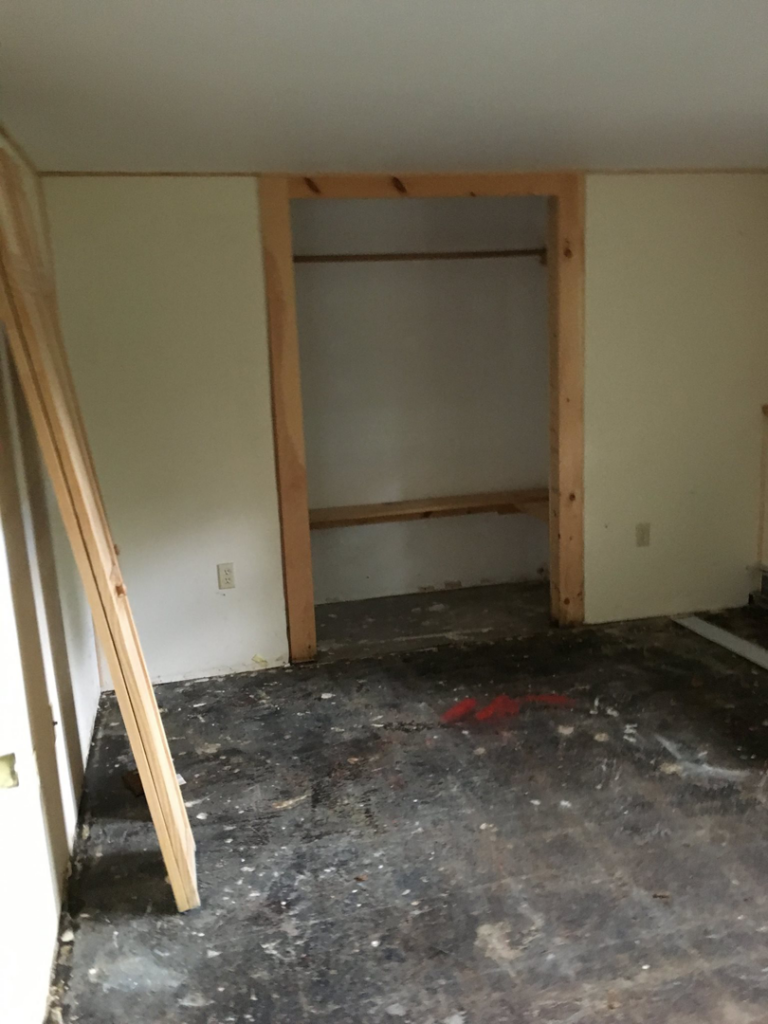 A room needing renovation with a dirty floor and an open closet, a typical handyman project for Lemelin General Contracting in Fall River, MA.
