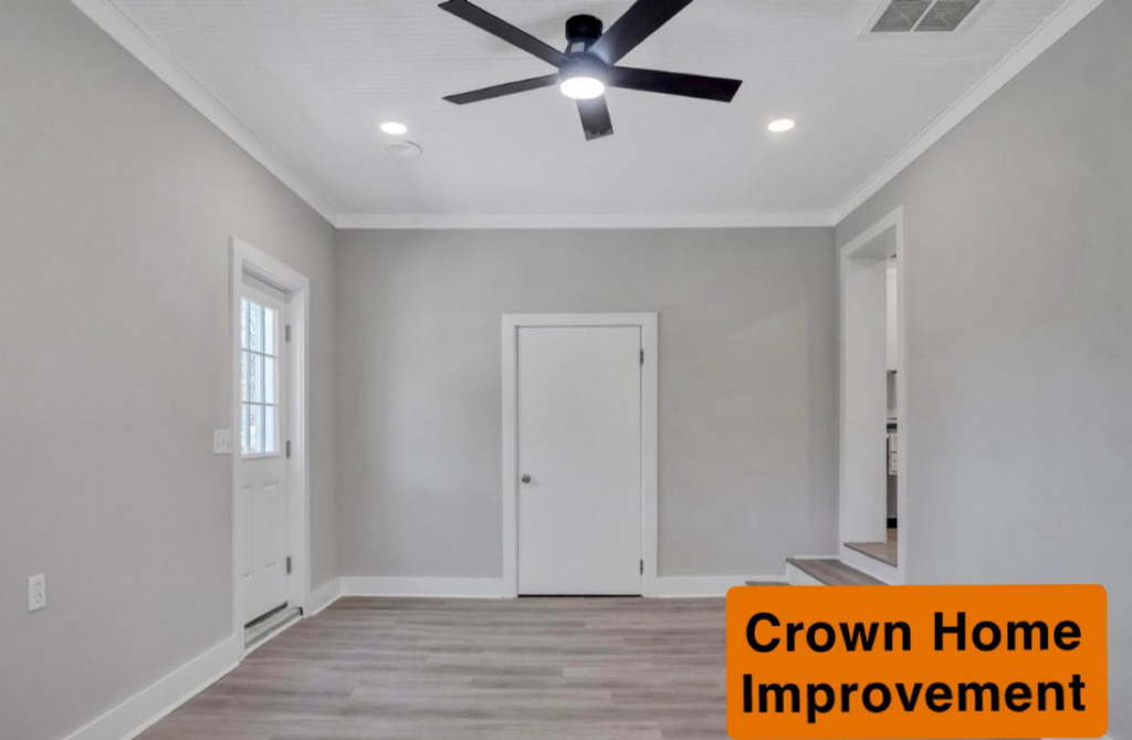 A renovated room with new flooring, fresh paint, a new ceiling fan, and recessed lighting installed by Crown Home Improvements in Charlotte, NC