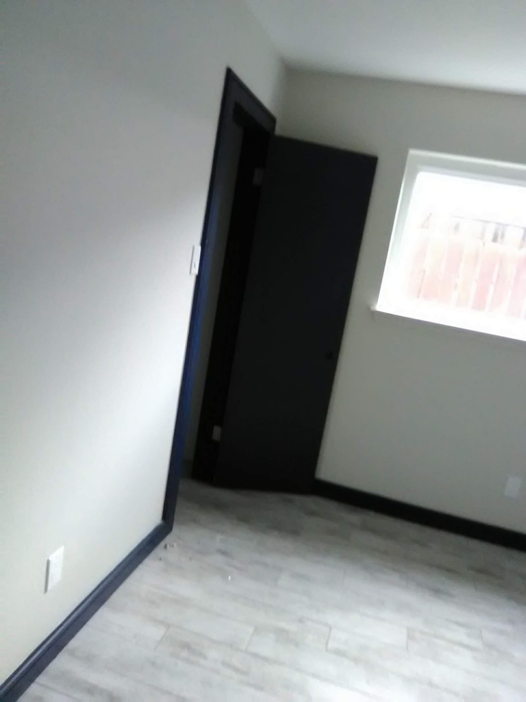 A room with newly installed flooring and dark trim by Pro Helping Hands Renovation in Colorado Springs, CO.