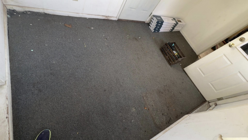 A room with old carpet and boxes of new flooring material, ready for installation by CJ Flooring LLC in Flat Rock, MI.