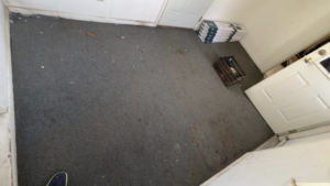A room with old carpet and boxes of new flooring material, ready for installation by CJ Flooring LLC in Flat Rock, MI.