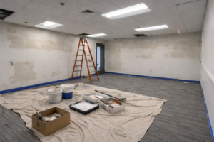 A room being prepped for painting with a ladder and supplies by New Chapter HI Services in Cambridge, MA.
