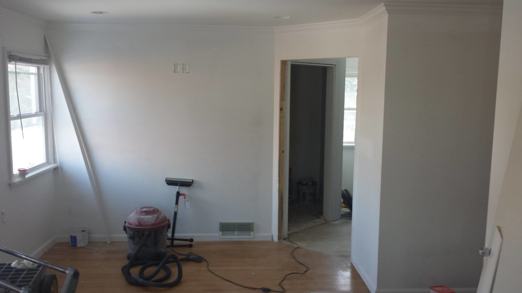 A room undergoing painting preparation with tools and partially painted walls by Precision Painters in Louisville, KY
