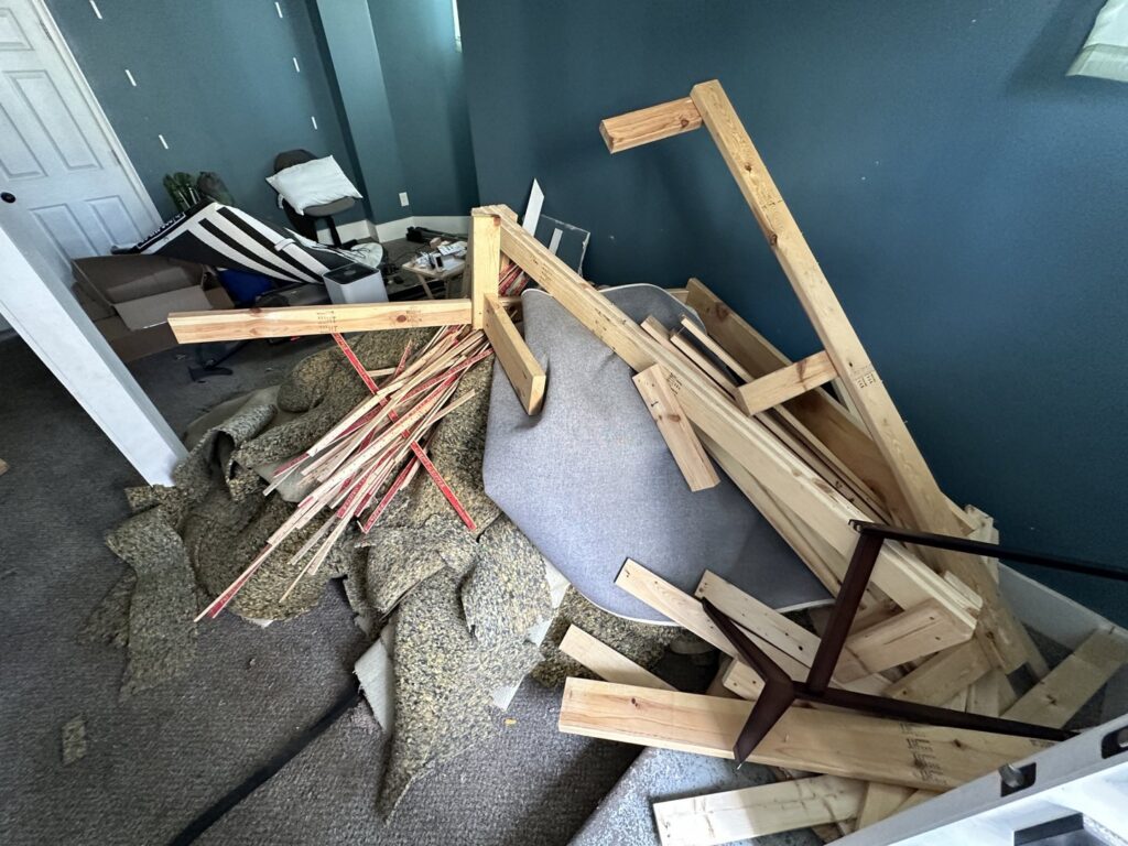 A room with dismantled furniture, carpet padding, and wood debris ready for renovation debris removal by Vargas Junk Removal & Dumpster Rentals in Urbandale, IA.