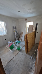 Room renovation with drywall, building materials, and ladder by Clausen Construction LLC in Williston, ND