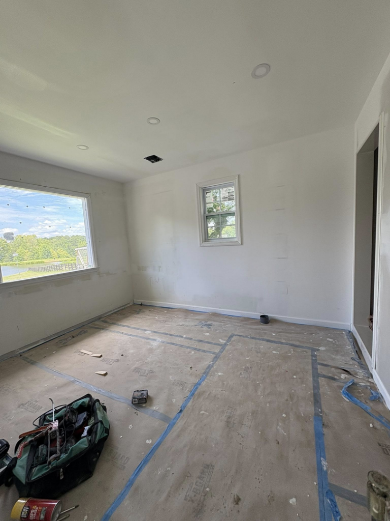 A room undergoing renovation with drywall and floor taping by Easier Remodeling LLC in Sandy Springs, GA.