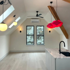 A renovated room with new lighting, ceiling fan, mini-split AC, and kitchen island by Buerger Brothers Construction in Lakewood, CO.