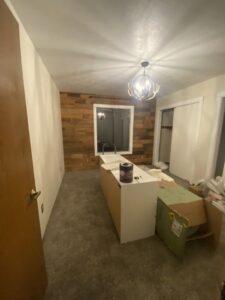 A room undergoing renovation with new wall paneling and kitchen cabinet installation by The Handy Nevadan LLC in Reno, NV.