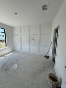 A room undergoing renovation, featuring newly installed decorative wall paneling by Roaring Lion Renovations, LLC in Houston, TX.