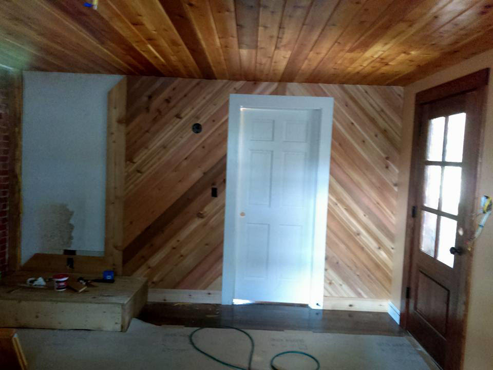 A renovated room featuring a wooden plank ceiling and diagonal wall paneling by Fryes Renovation and Improvements in Johnson City, TN.