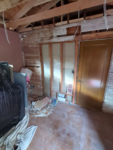 A room undergoing renovation with exposed lath and framing by Becker Custom Construction - pdx in Oak Grove, OR.