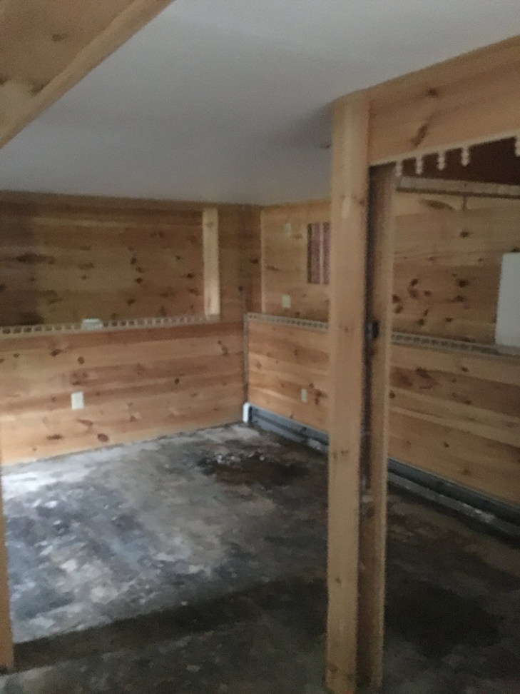 A room under renovation with wood paneling and exposed framing, showcasing handyman services by Lemelin General Contracting in Fall River, MA.
