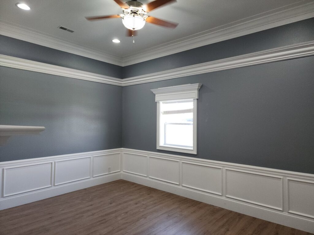 A finished room featuring elegant wainscoting, crown molding, and painted walls by FG Drywall, Finishing and Painting in Champaign, IL.