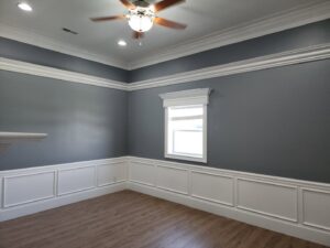 A finished room featuring elegant wainscoting, crown molding, and painted walls by FG Drywall, Finishing and Painting in Champaign, IL.