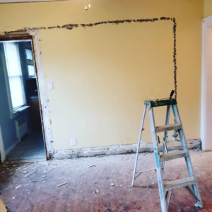A room undergoing wall repair or painting preparation with a ladder by CJM Builders Inc in Wilmington, MA.