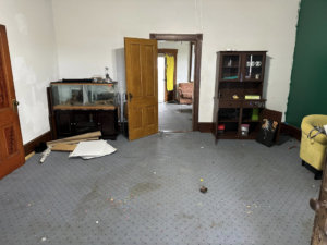 A room with an aquarium stand, hutch, and scattered debris on the floor, indicating a space ready for junk removal by Sinclair Waste Removal & Hauling LLC in St. Charles, MO.