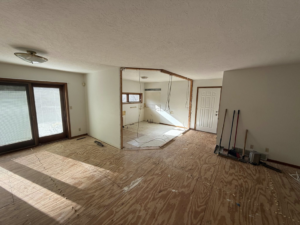 A room with a partially demolished wall and exposed subfloor during a renovation by A&B Snow, Mow, and Contracting in Sioux City, IA.