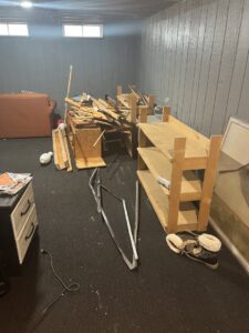 A room with disassembled wooden furniture and metal pieces on the floor, ready for removal by Prestige Junk Removal & Hauling in Detroit, MI.