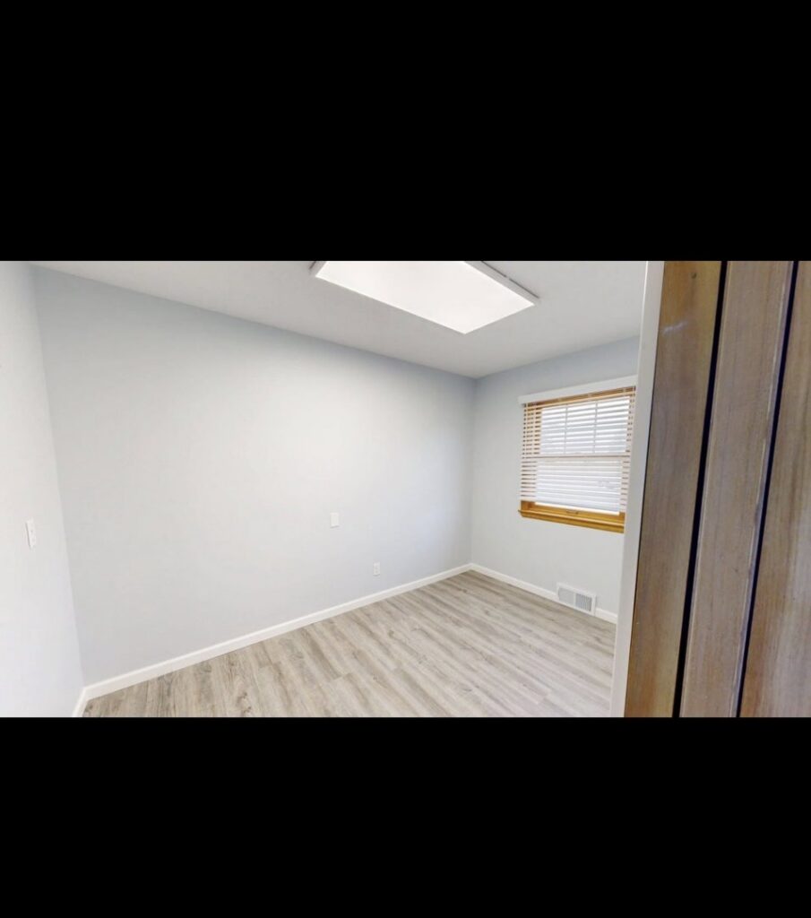 A room featuring fresh paint on the walls and newly installed laminate flooring, completed by EJ Drywall Plus in Kearney, NE.