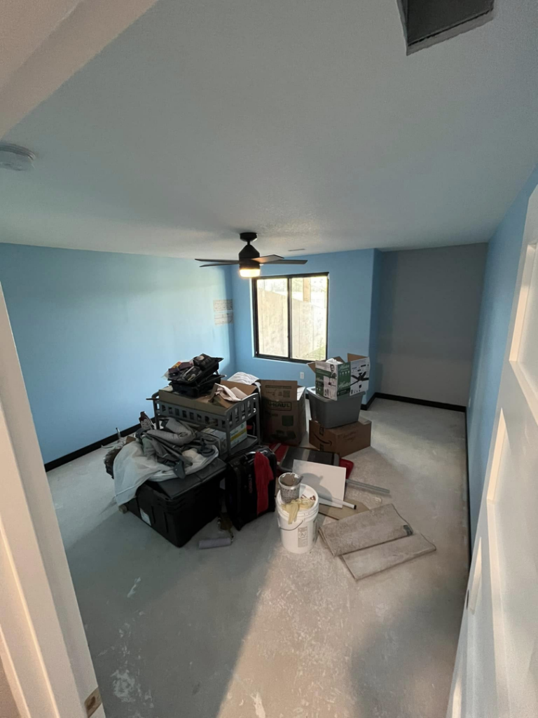 A room with a newly installed ceiling fan and light blue painted walls, showing home repair by Drew's Home Repair and Handyman Service in Wichita, KS.