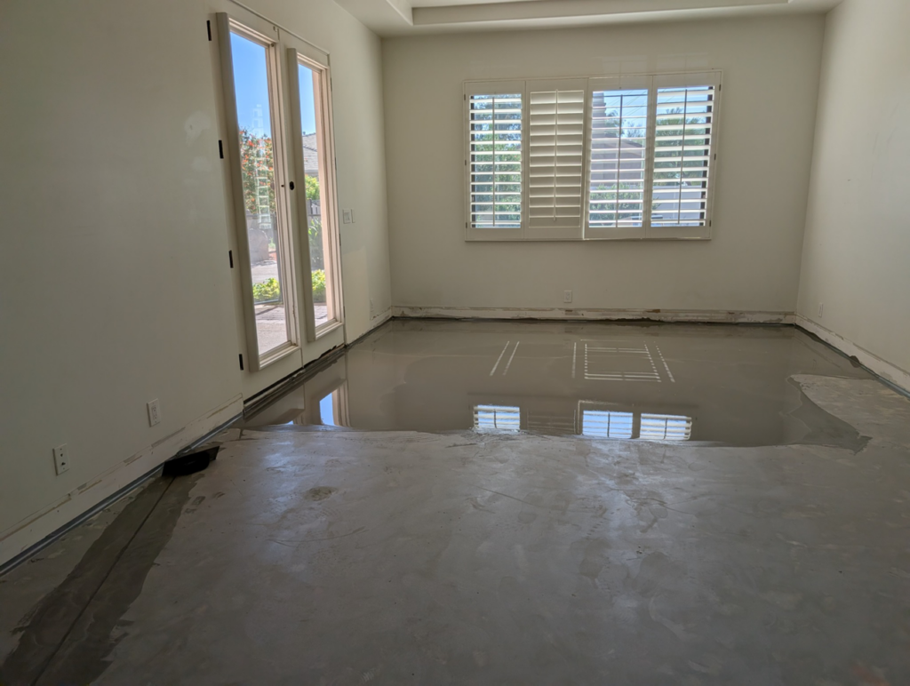 A room with newly applied self-leveling compound on the floor by Prestwick Custom Homes in Gilbert, AZ