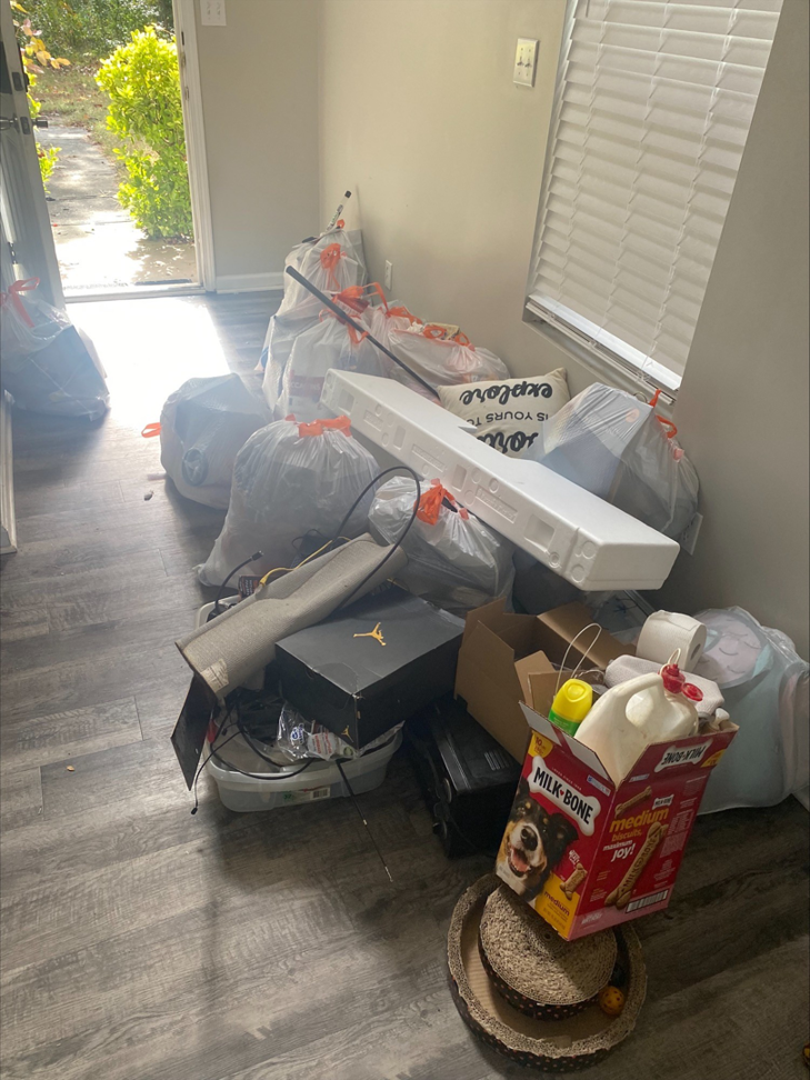 A room filled with piles of trash bags, boxes, and various household junk, awaiting removal by Restoration Hauling Co. in Rock Hill, SC.