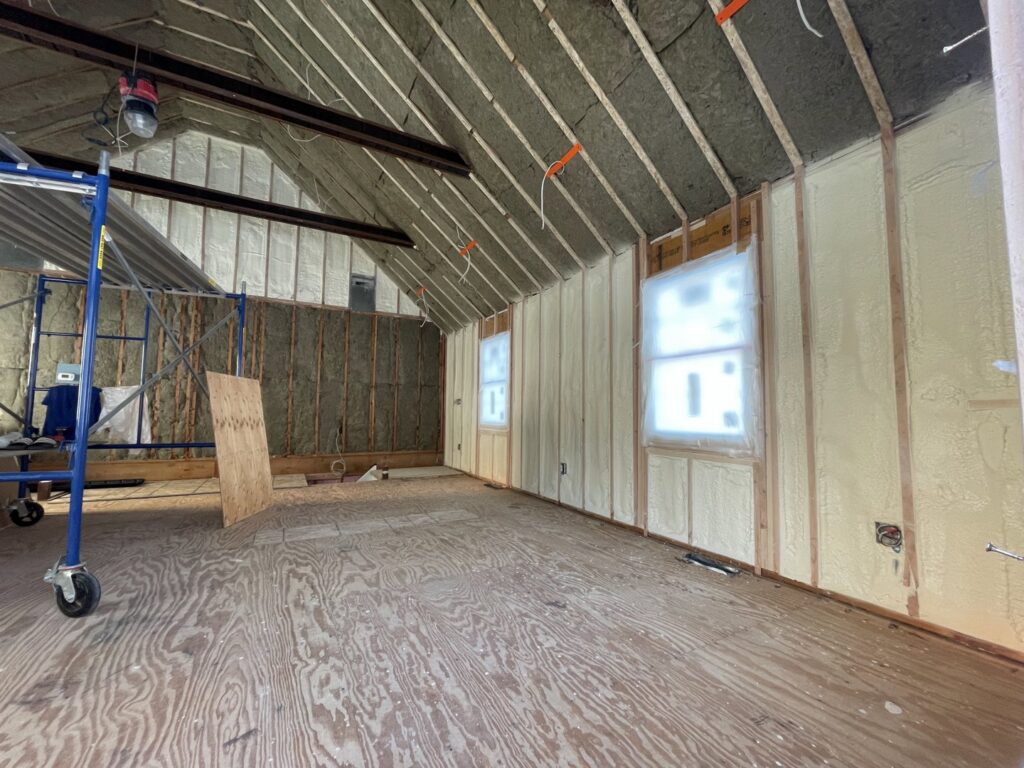 An unfinished room showing both spray foam and fiberglass insulation applied to walls and ceiling by Spray Foam Art-Insulation in Stamford, CT.