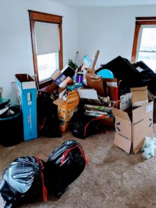 A room filled with black trash bags, cardboard boxes, and various items ready for junk removal by Junken Monkeys Hauling Company in Scranton, PA.