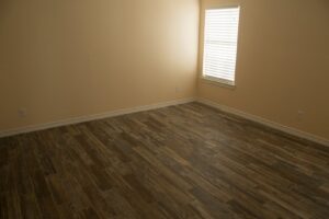 A newly renovated room featuring stylish wood-look tile flooring and freshly painted walls, completed by Custer Remodeling in Plano, TX.