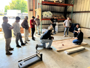 A group of Roomflip handymen receiving training on flooring installation techniques in Millville, DE.