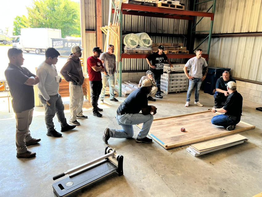 A group of Roomflip handymen receiving training on flooring installation techniques in Millville, DE.