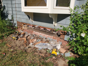 Exterior of a house showing rotted sill removal and debris during a handyman project by Richard C. Michalak in Worcester, MA.