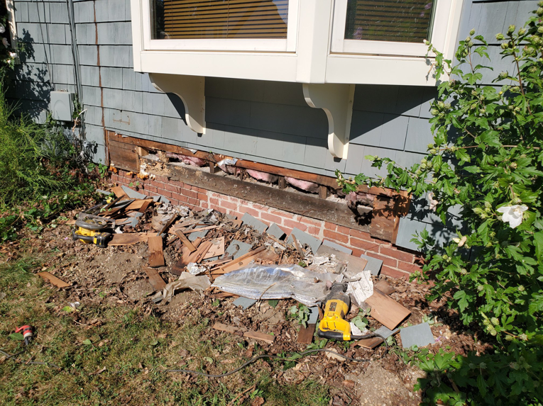 Exterior of a house showing rotted sill removal and debris during a handyman project by Richard C. Michalak in Worcester, MA.