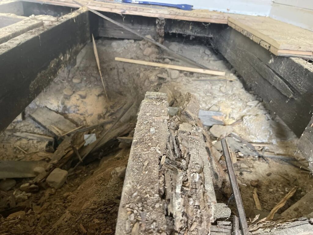 Close-up of rotten wooden floor joists needing structural repair from Appalachian Foundation Services in Roanoke, VA.
