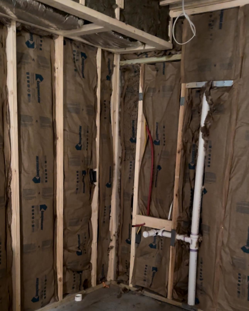 Rough-in plumbing and insulation within wall framing during a renovation by Under The Wire Renovations in Atlanta, GA.