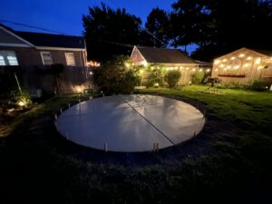 A newly installed round concrete pad in a backyard at night, completed by Moons Concrete & Construction LLC in Chicago, IL.