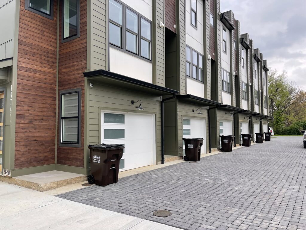 A row of J.E. McMurtry Disposal & Recycling trash bins on a residential street in Nashville, TN.