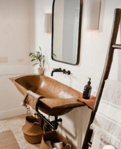 A unique rustic wooden bathroom sink and black wall-mounted faucet installed by Read Plumbing LLC in Ankeny, IA.