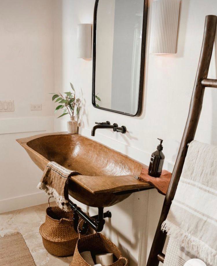 A unique rustic wooden bathroom sink and black wall-mounted faucet installed by Read Plumbing LLC in Ankeny, IA.