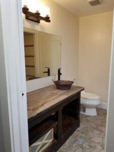 A bathroom featuring a rustic wooden vanity with a vessel sink, installed by M J Services Home Remodeling in Gaithersburg, MD.