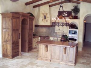 A rustic kitchen remodel featuring wooden cabinets, a large island, and exposed beams by Kornerstone Kitchens in Orlando, FL.