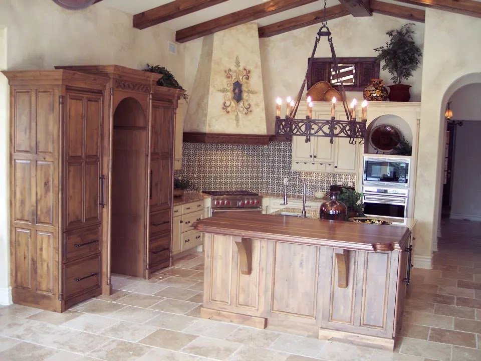 A rustic kitchen remodel featuring wooden cabinets, a large island, and exposed beams by Kornerstone Kitchens in Orlando, FL.