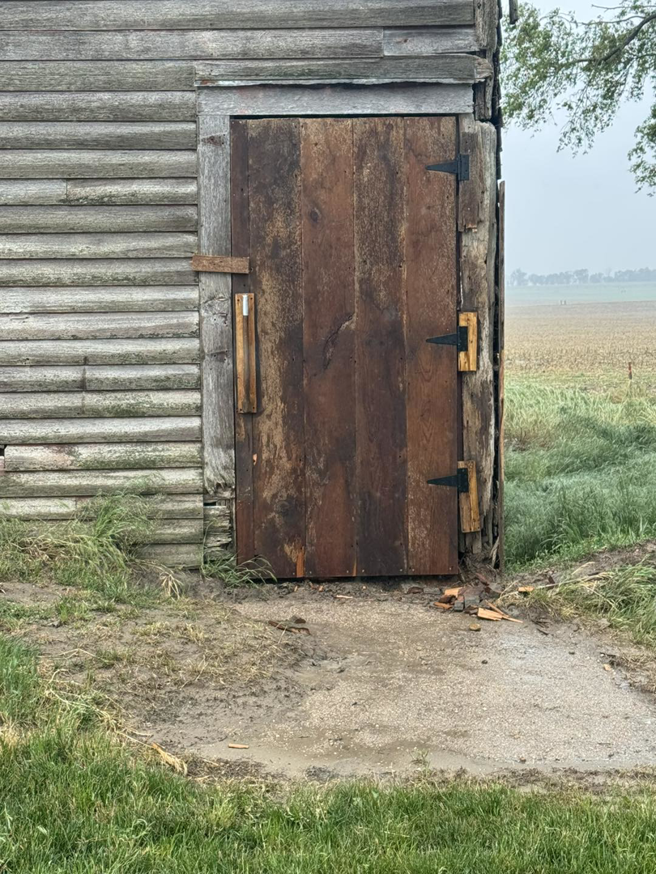A newly installed rustic wooden door on an old building by Shurigar Home Repair & Handyman in Kenesaw, NE.