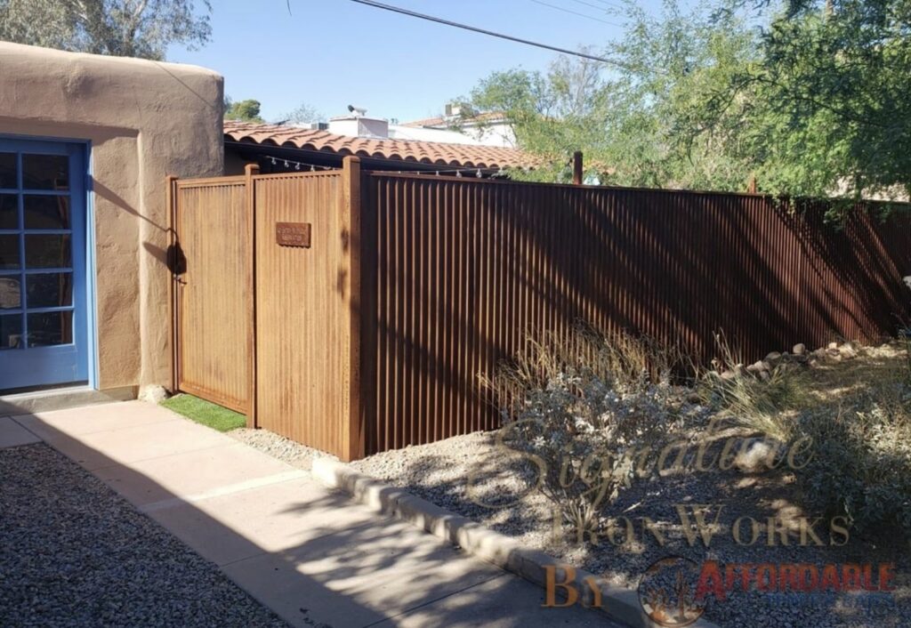 A rusty corrugated metal fence and gate installed by Affordable Fence & Gates in Tucson, AZ.
