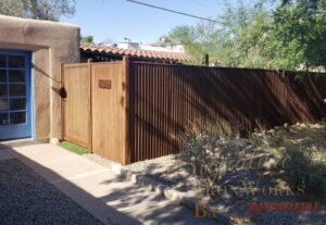 A rusty corrugated metal fence and gate installed by Affordable Fence & Gates in Tucson, AZ.