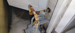 Rusty exterior pipes and a gas meter on the side of a house, a common repair job for C&J Contractors & Waterproofing MD in Baltimore, MD.