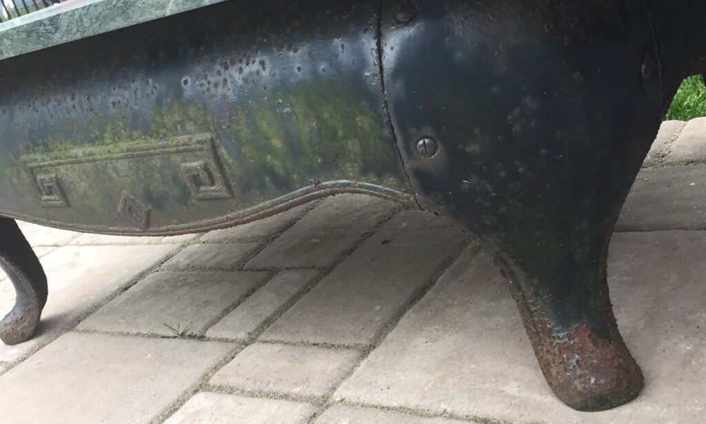 A rusty, old metal object, possibly a bathtub or basin, showing corrosion before a coating service by Vanwin Coatings of Virginia in Chesapeake, VA.