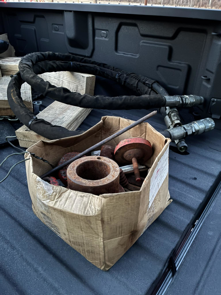Rusty metal parts and a coiled hose in a truck bed for junk removal by Tracer Transport LLC in Fort Wayne, IN.