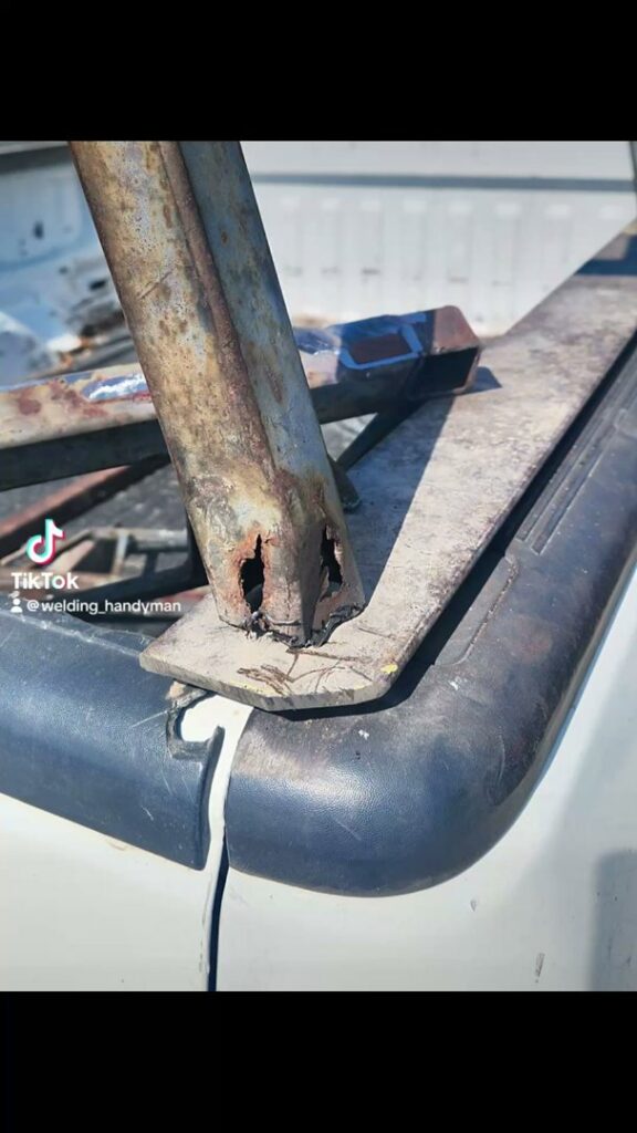 A close-up of a rusty metal truck rack or trailer part, indicating potential repair or fabrication work by Jeremy's Welding & Handyman in West Jordan, UT.