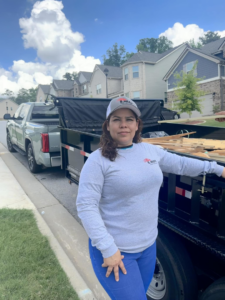 A S.WAT Junk Removal team member standing next to a truck and trailer loaded with debris in Roswell, GA